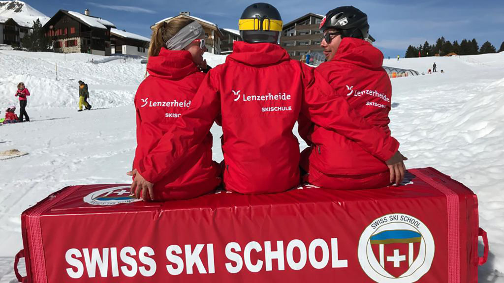 Drei Skilehrer die sich umarmen