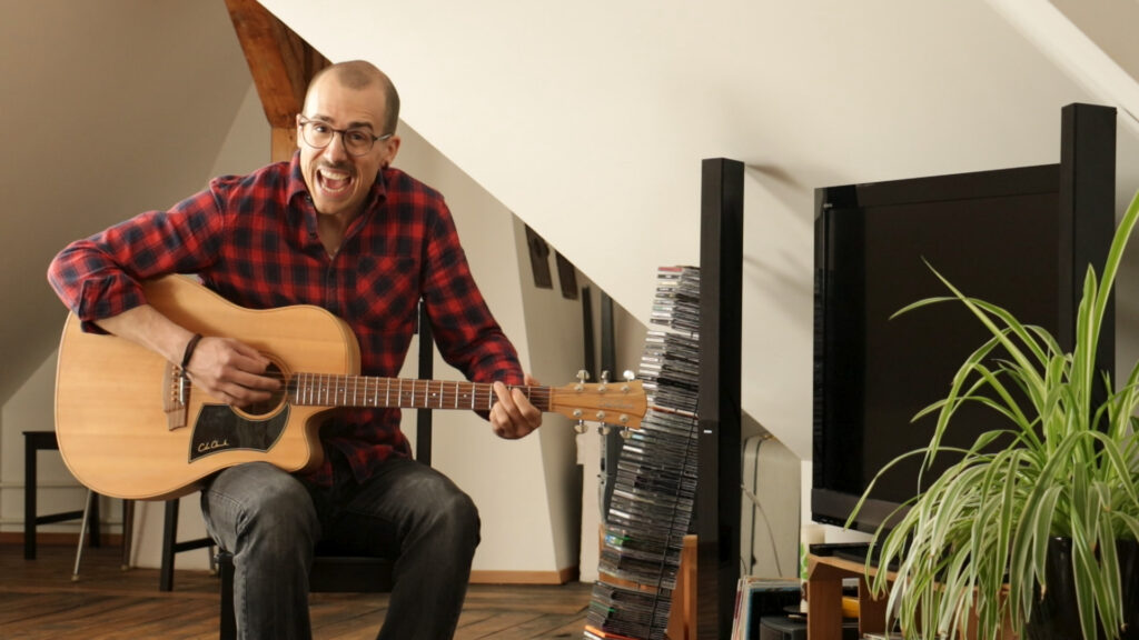 Musiker spielt in Wohnzimmer Gitarre